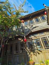 庭院中央,水系潺潺,一座雕刻著大鵬神鳥的東巴柱靜靜屹立。